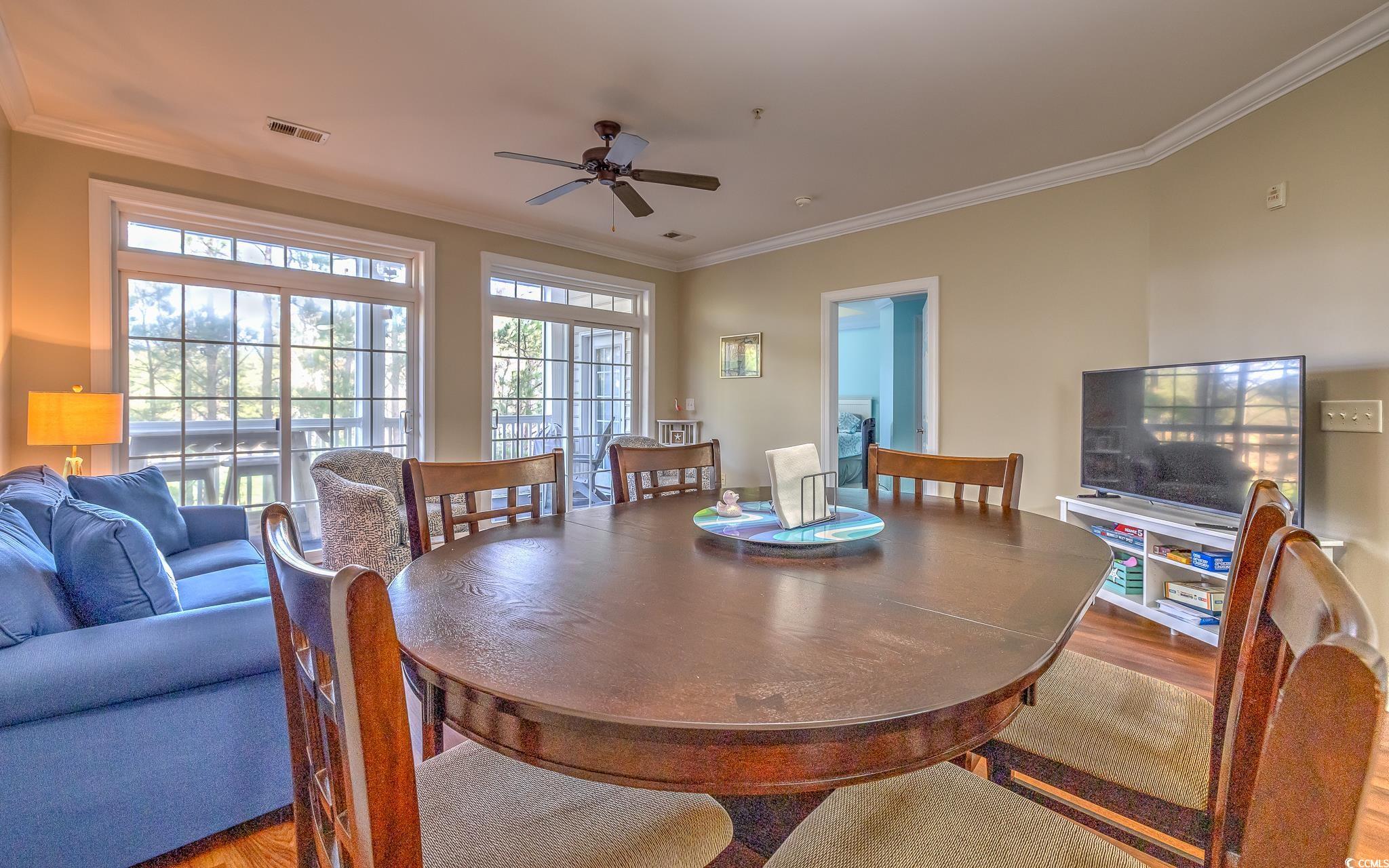 719 Shearwater Court, Unit 303 Murrells Inlet, SC 29576 - Photo 14 of 20 Dining space featuring crown molding, a ceiling fan, and wood finished floors