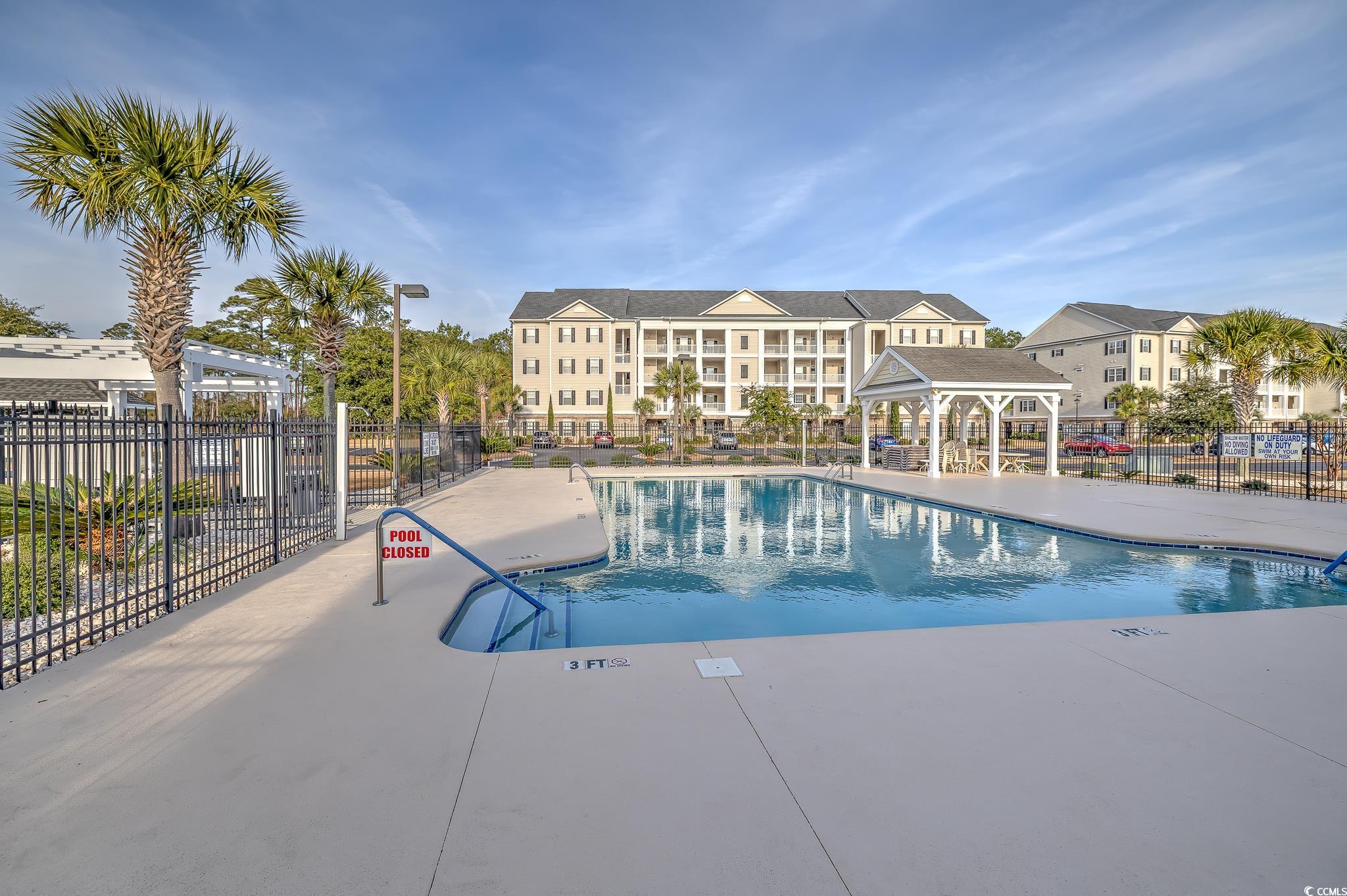 719 Shearwater Court, Unit 303 Murrells Inlet, SC 29576 - Photo 2 of 20 Community pool featuring a gazebo and a patio