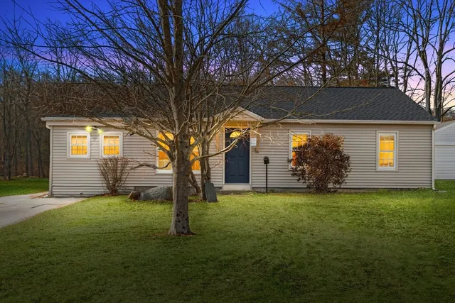 a view of a yard in front of a house with large tree