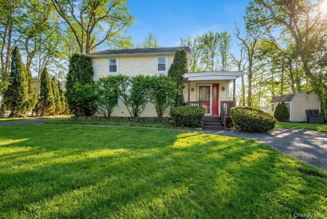 a view of an house with backyard and a tree