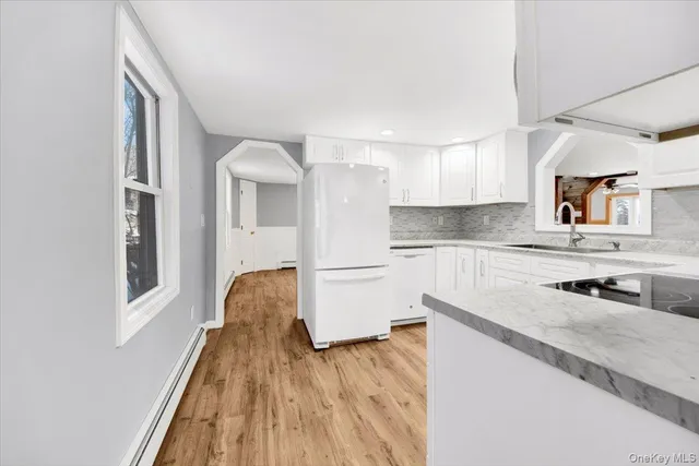 a kitchen with a refrigerator sink and cabinets