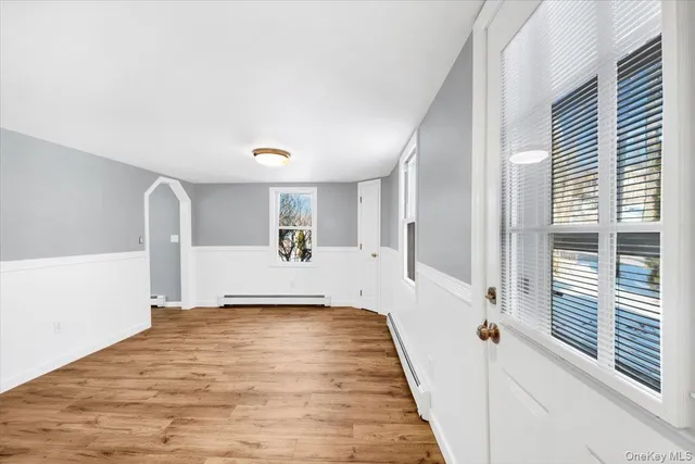 a view of a livingroom with wooden floor and a large window