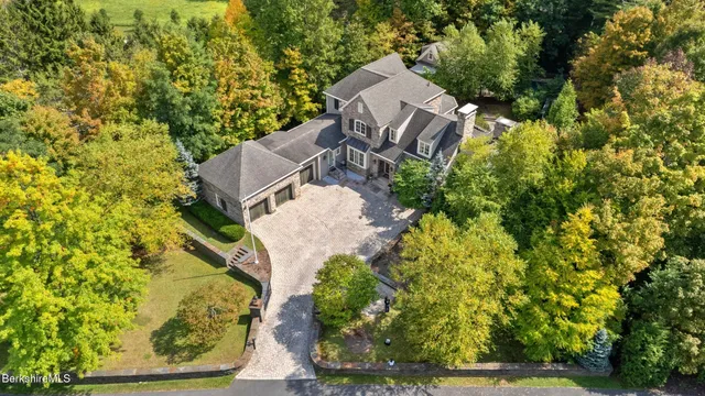 an aerial view of a house with a yard basket ball court and outdoor seating