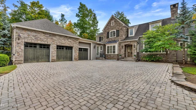 a front view of a house with a yard and potted plants