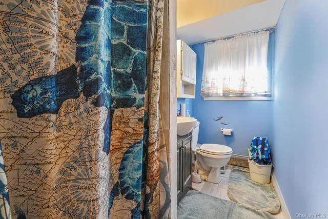 a bathroom with a toilet and a shower curtain