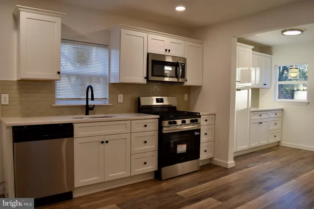 a kitchen with stainless steel appliances a stove microwave and sink