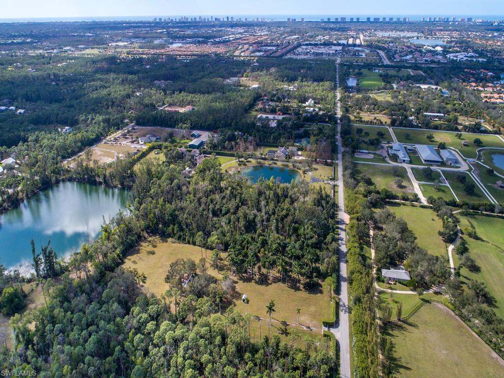 an aerial view of residential houses with outdoor space and lake view