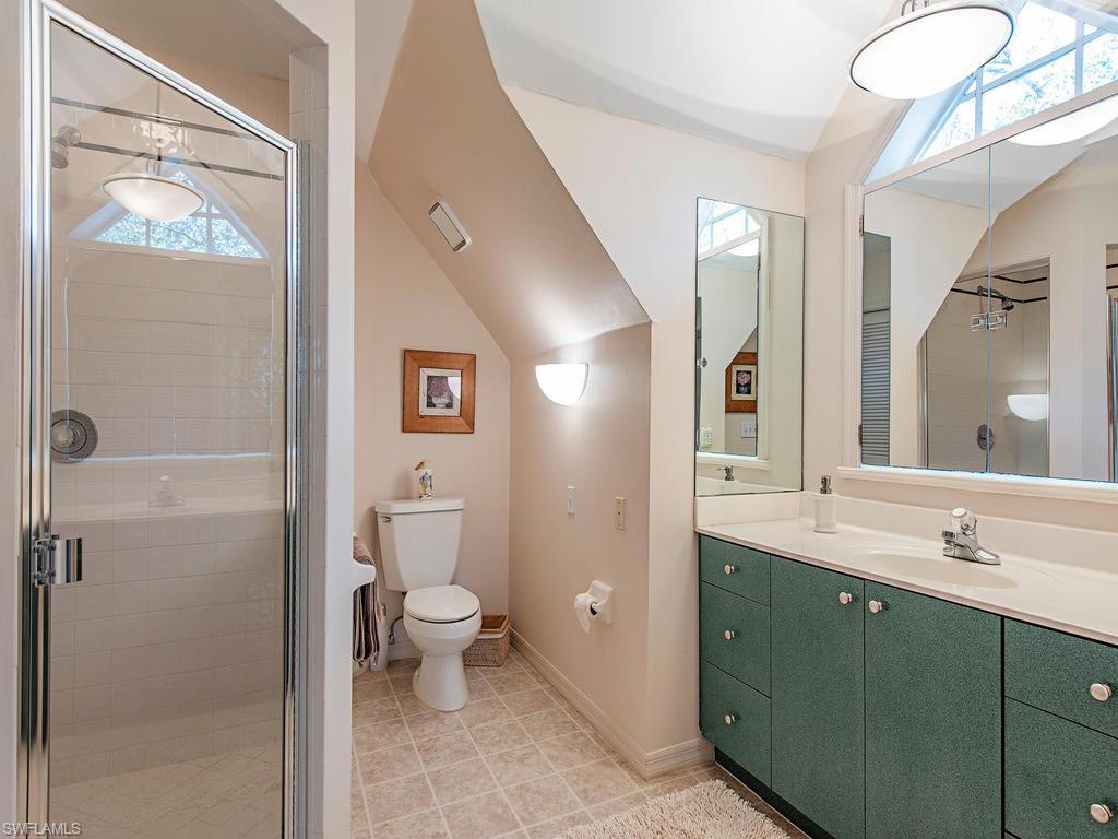 6470 Daniels Road Naples, FL 34109 - Photo 17 of 22 a spacious bathroom with a toilet sink and a mirror
