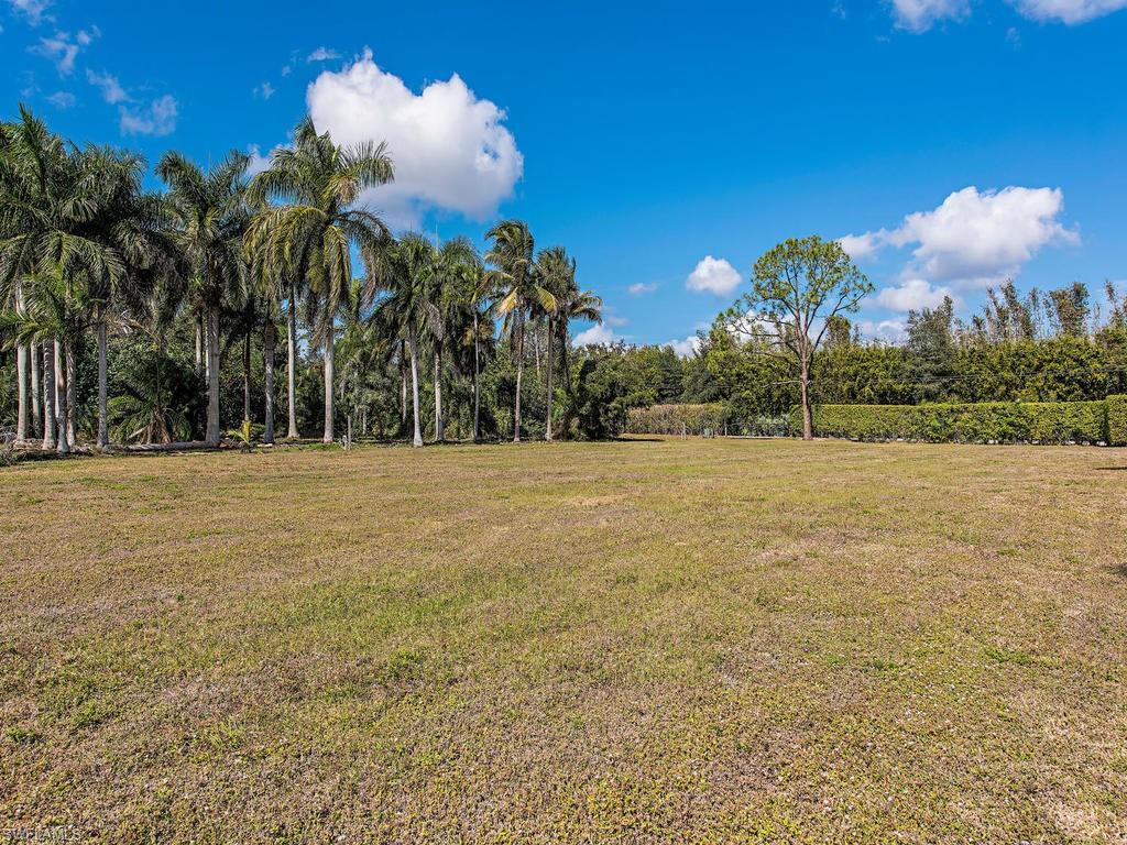 6470 Daniels Road Naples, FL 34109 - Photo 22 of 22 a view of a fountain in front of a house with a yard