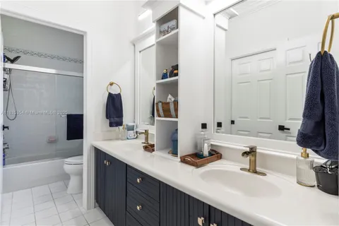 a bathroom with a double vanity sink toilet and shower
