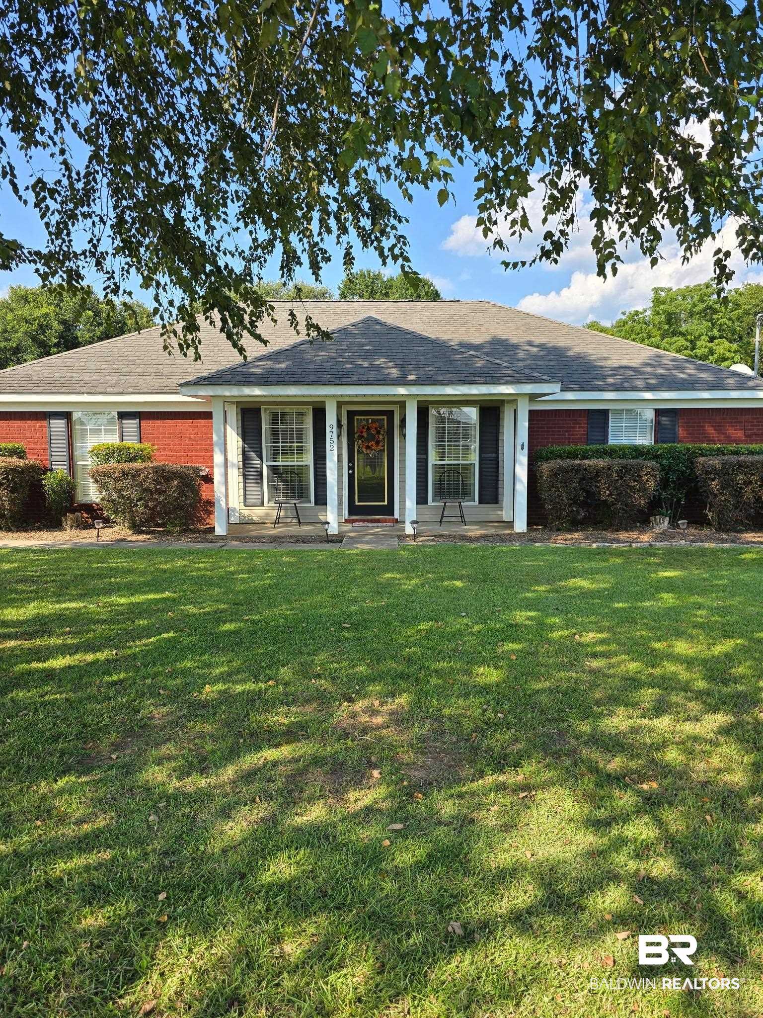 9752 Brighton Drive South Chunchula, AL 36521 - Photo 1 of 1 Single story home featuring a front lawn, brick siding, covered porch, and roof with shingles