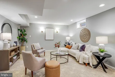 a living room with furniture a clock and a rug