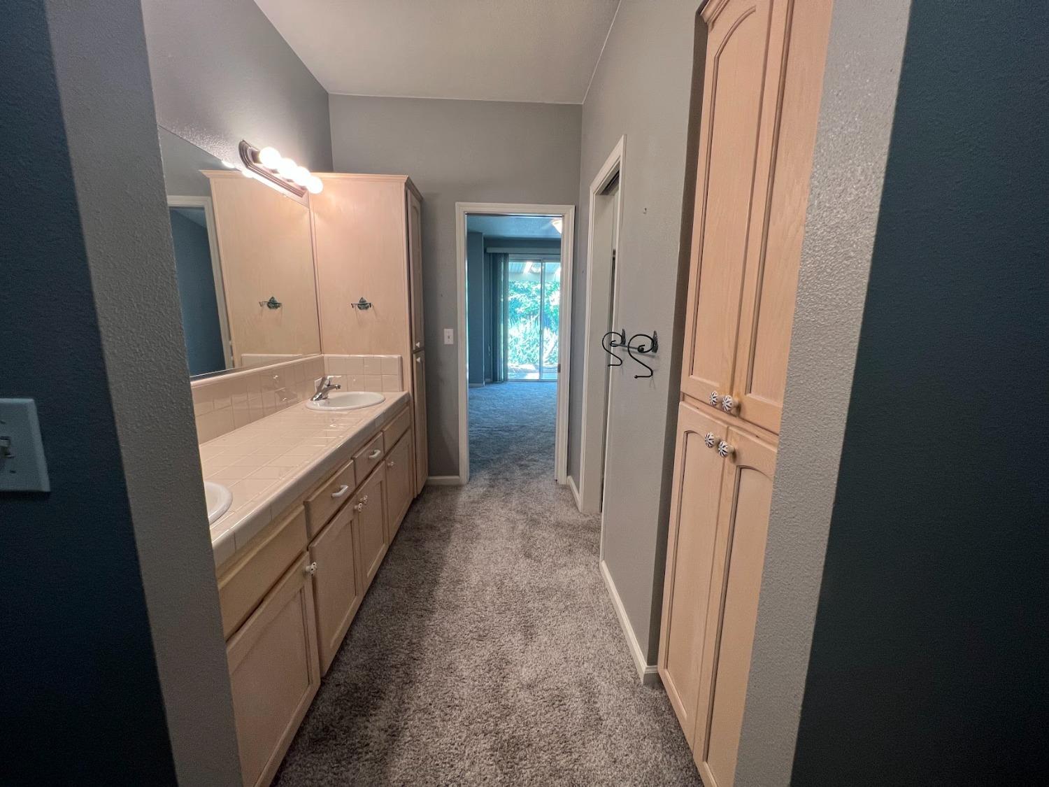 Undisclosed Address Dinuba, CA 93618 - Photo 25 of 45 a bathroom with a double vanity sink and mirror with bathtub