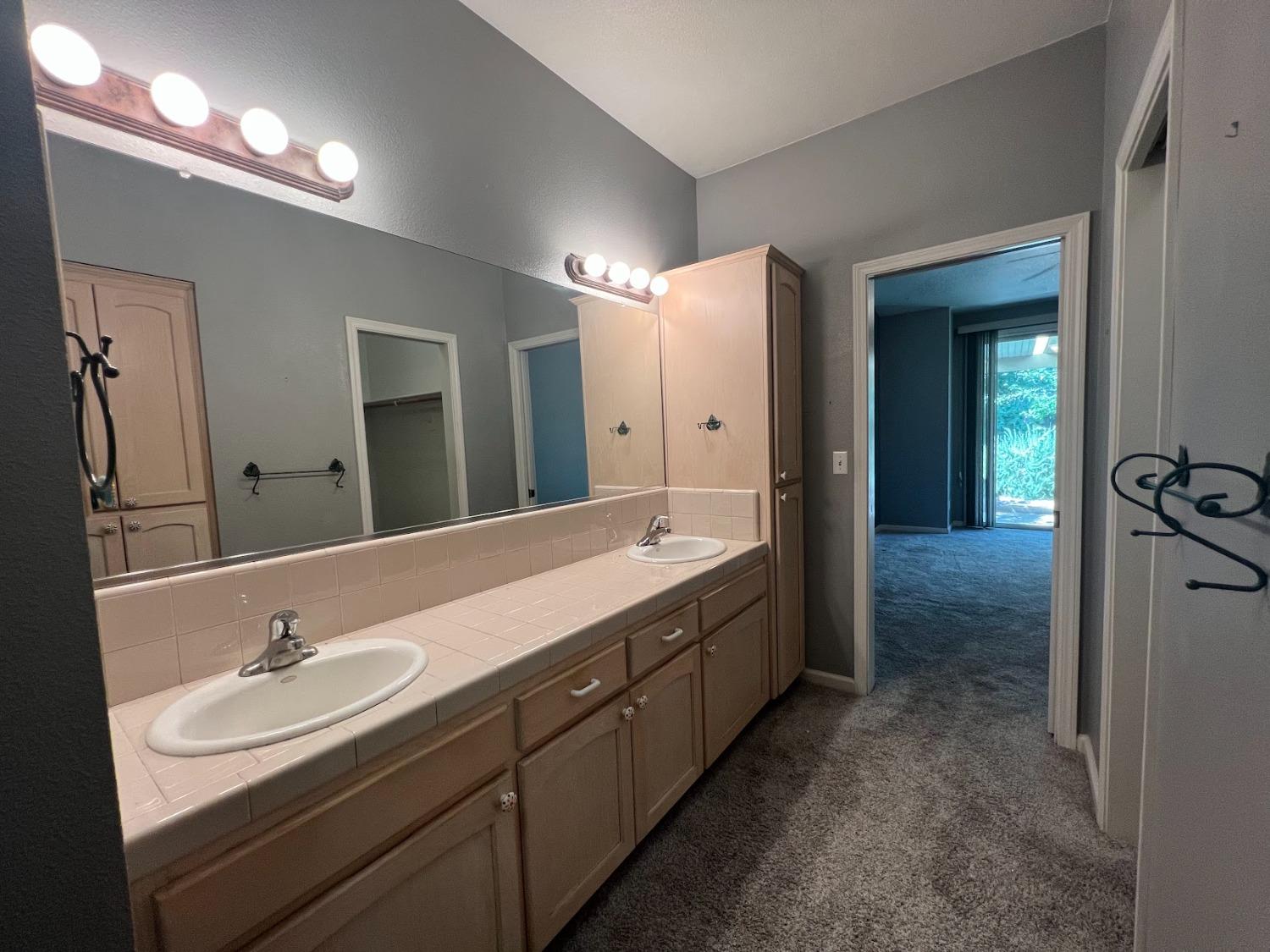 Undisclosed Address Dinuba, CA 93618 - Photo 26 of 45 a bathroom with a double vanity sink and a mirror