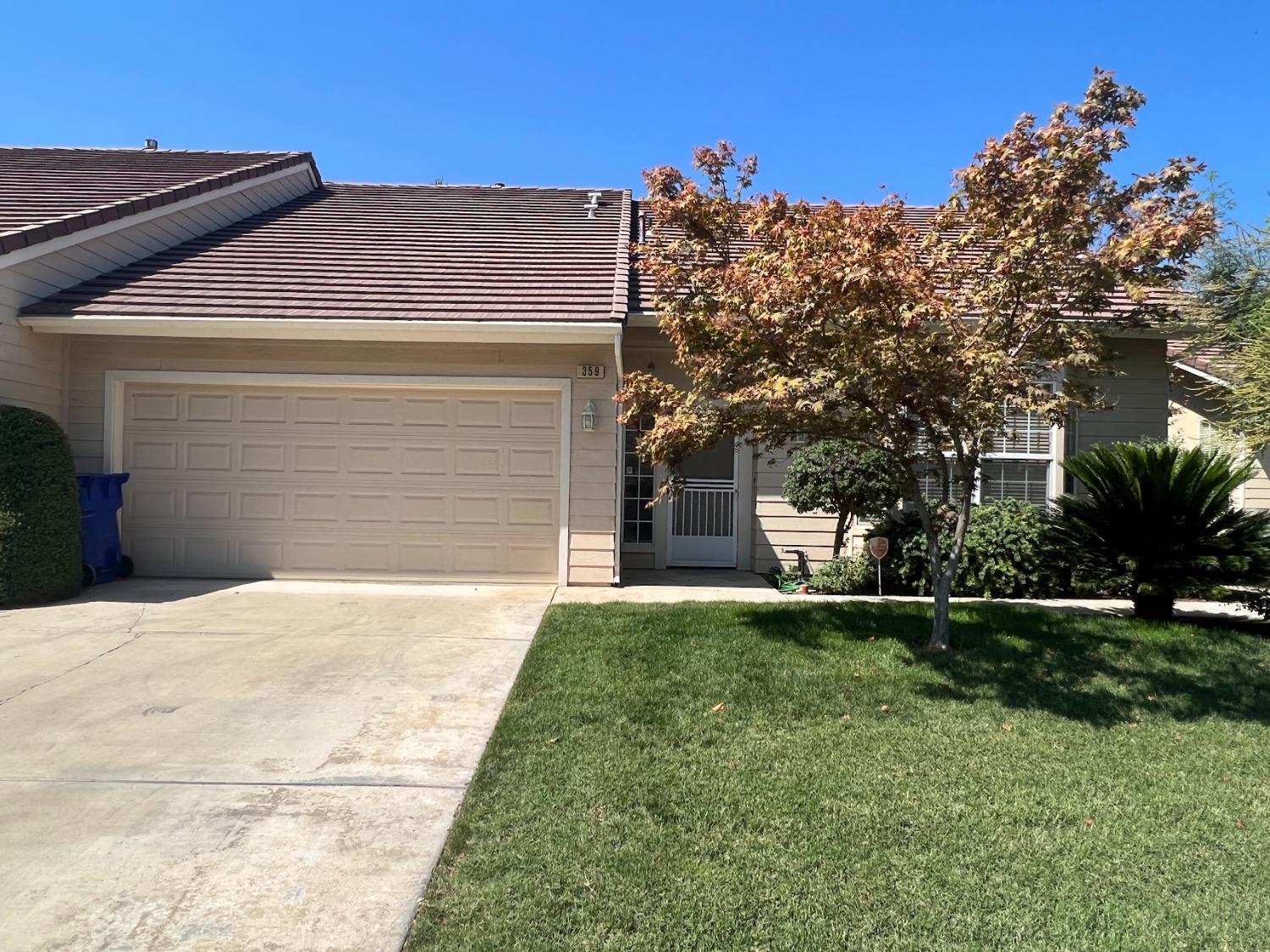 Undisclosed Address Dinuba, CA 93618 - Photo 4 of 45 a front view of a house with a yard and garage