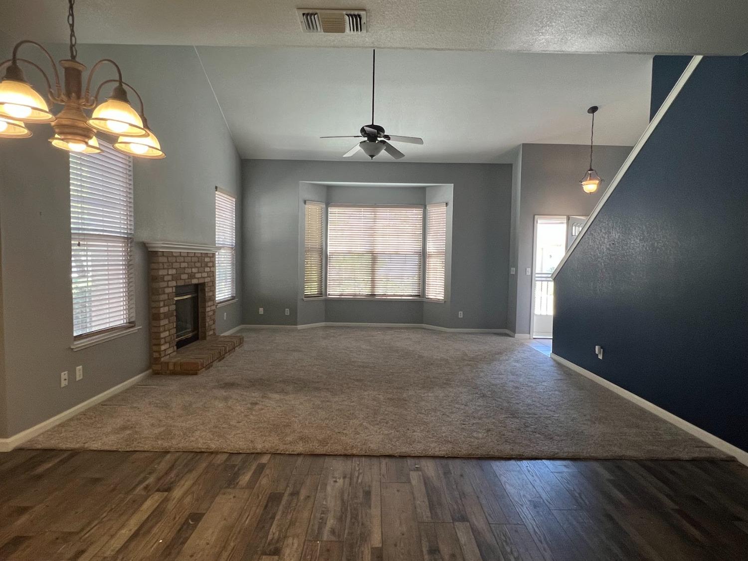 Undisclosed Address Dinuba, CA 93618 - Photo 6 of 45 an empty room with windows and fireplace