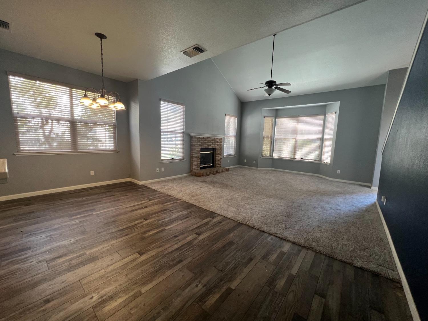 Undisclosed Address Dinuba, CA 93618 - Photo 7 of 45 an empty room with windows and chandelier