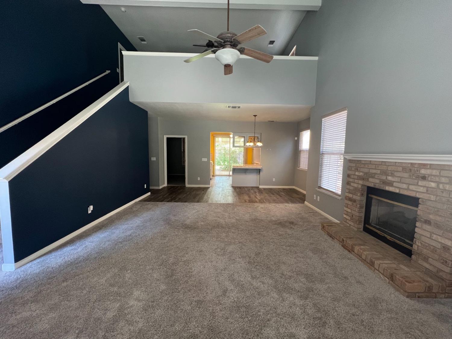 Undisclosed Address Dinuba, CA 93618 - Photo 8 of 45 a view of a livingroom with a fireplace a chandelier and windows