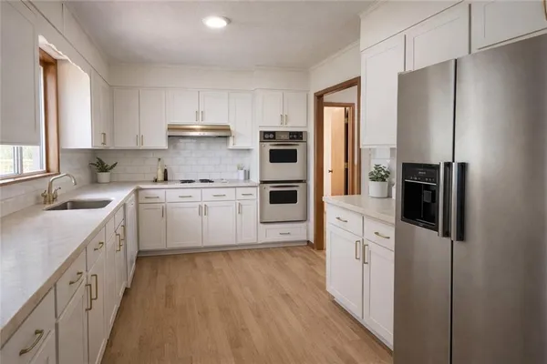 a kitchen with stainless steel appliances a refrigerator sink and cabinets