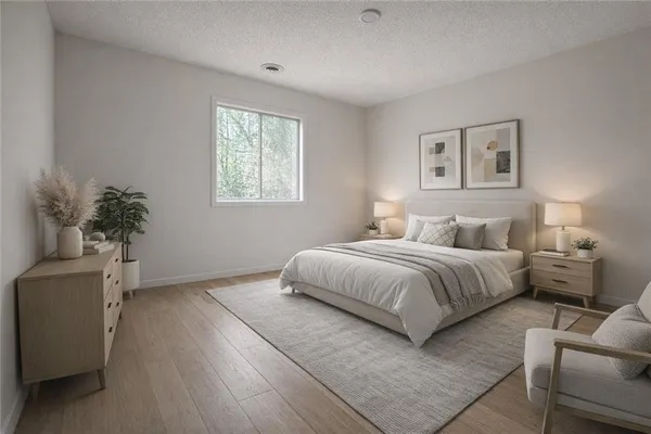 a bedroom with a large bed and a potted plant