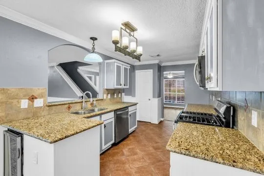 a kitchen with a granite countertop sink and stove