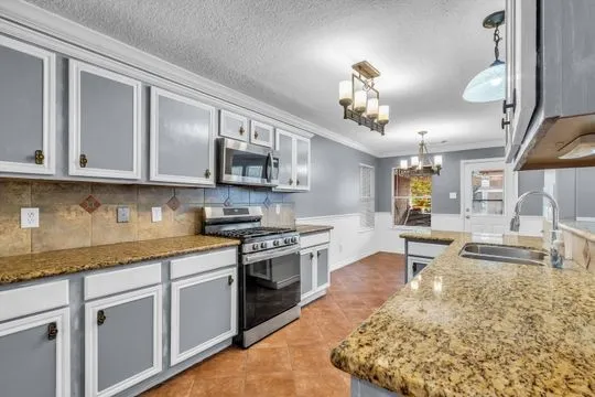 a kitchen with stainless steel appliances granite countertop a sink dishwasher stove and oven with wooden floor