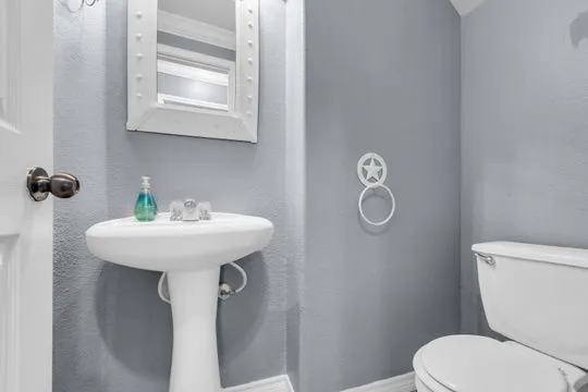 a bathroom with a toilet sink and mirror
