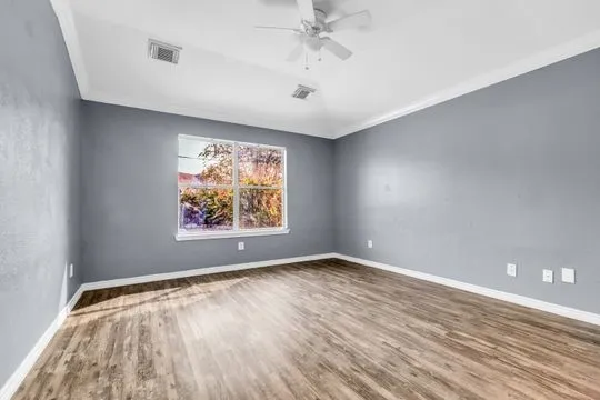 wooden floor in an empty room with a window