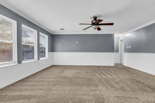 a view of a livingroom with a ceiling fan and window