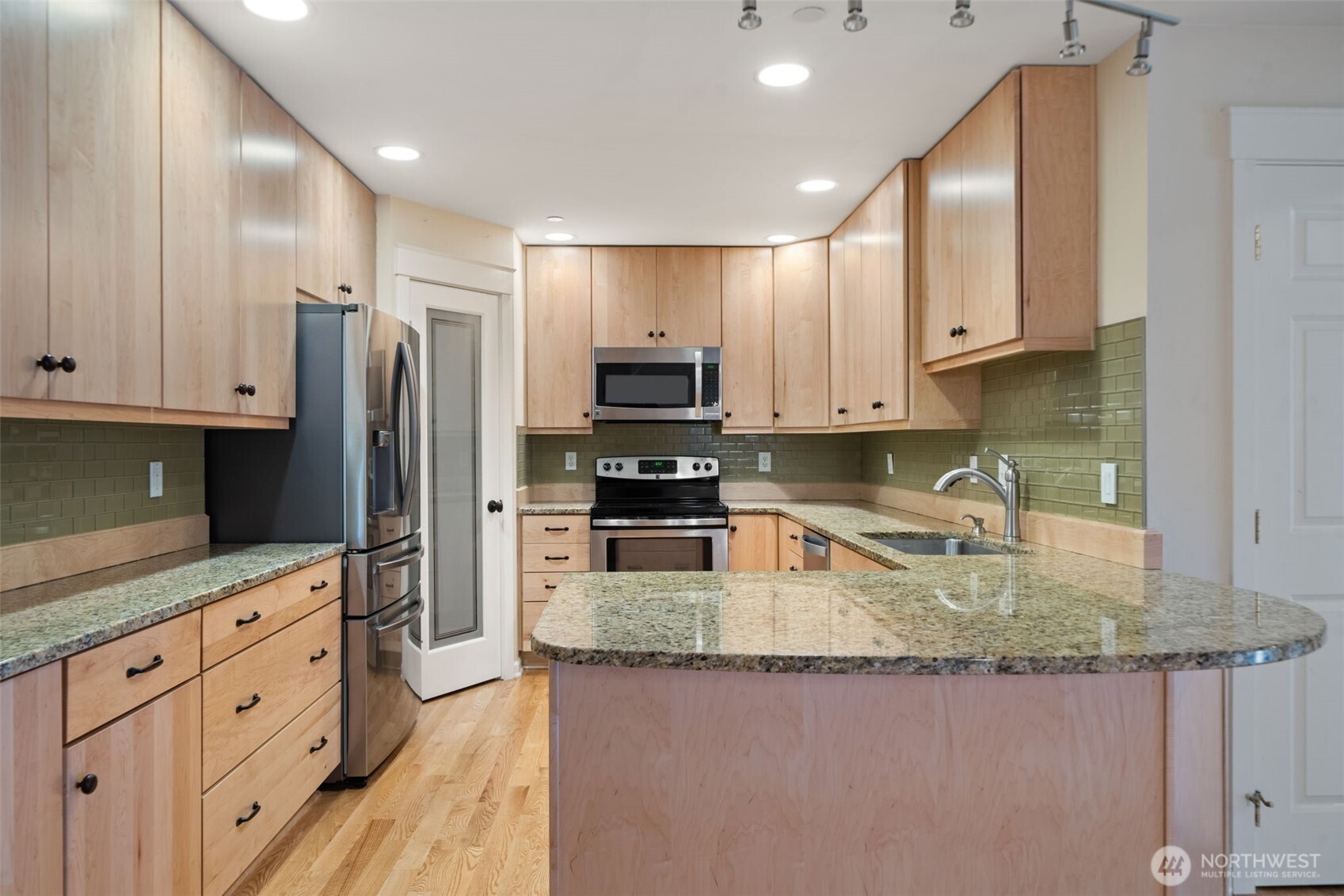 321 East Soderberg Road, Unit D12 Allyn, WA 98524 - Photo 16 of 37 a kitchen with granite countertop a refrigerator a stove a sink a counter space and cabinets