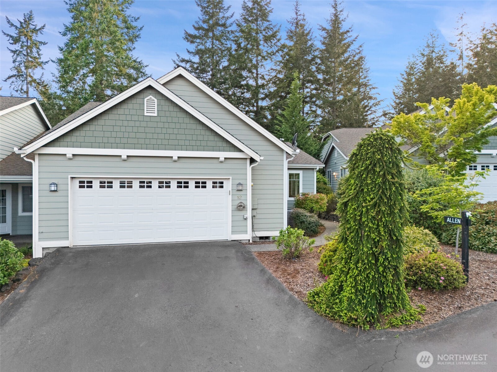 321 East Soderberg Road, Unit D12 Allyn, WA 98524 - Photo 34 of 37 a view of a house with a small yard and garage