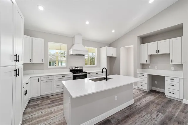 a kitchen with a sink white cabinets and white appliances