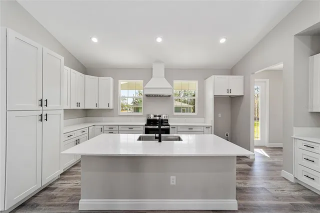 a kitchen with kitchen island a stove a sink and a refrigerator