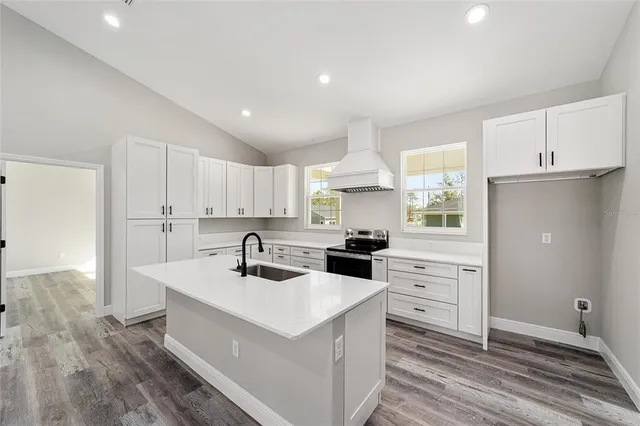 a kitchen with granite countertop a sink stove and refrigerator