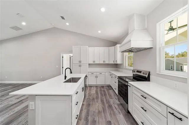 a kitchen that has a lot of cabinets and wooden floor