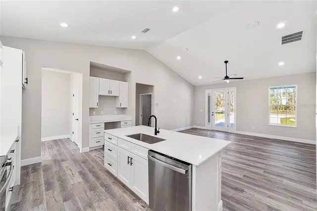 a view of a kitchen with a sink a window and stainless steel appliances