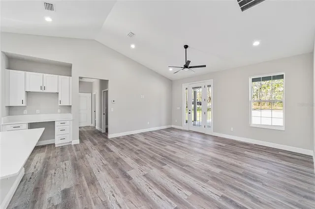 a view of a kitchen with wooden floor and a window