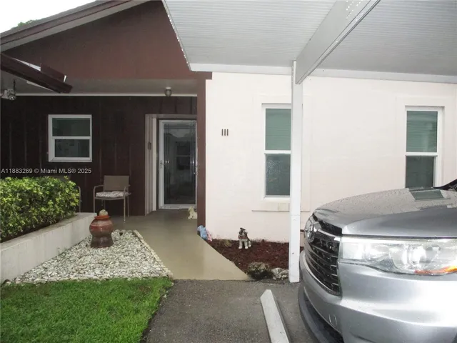 a view of a house with a yard and a large tree