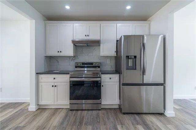 a kitchen with a refrigerator stove and wooden cabinets
