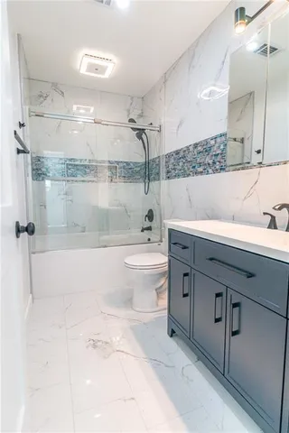 a bathroom with a bathtub shower sink mirror and toilet