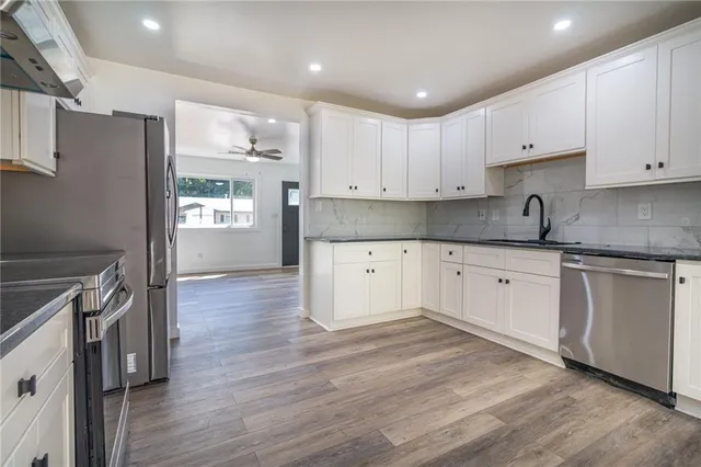 a kitchen with granite countertop a sink stove and cabinets