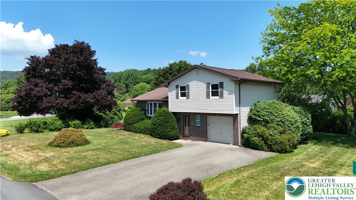 21 Will Barnesville, PA 18214 - Photo 2 of 23 Mature trees and lush landscaping frame this inviting residence, featuring a convenient attached garage.