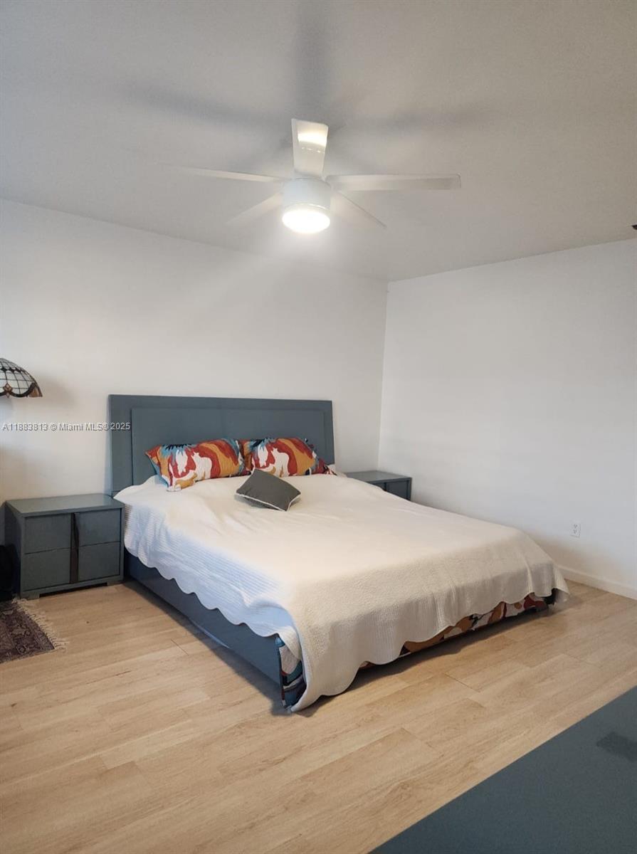 11960 Northeast 19th Drive, Unit 10 North Miami, FL 33181 - Photo 11 of 40 a bedroom with a bed and a night stand