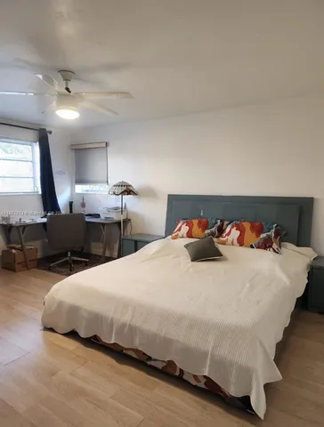 a large bed sitting in a bedroom next to a lamp