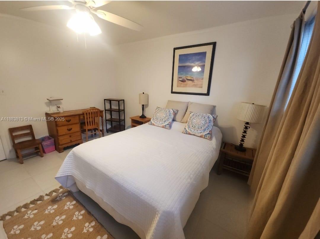 11960 Northeast 19th Drive, Unit 10 North Miami, FL 33181 - Photo 13 of 40 a bedroom with a bed and a lamp with window