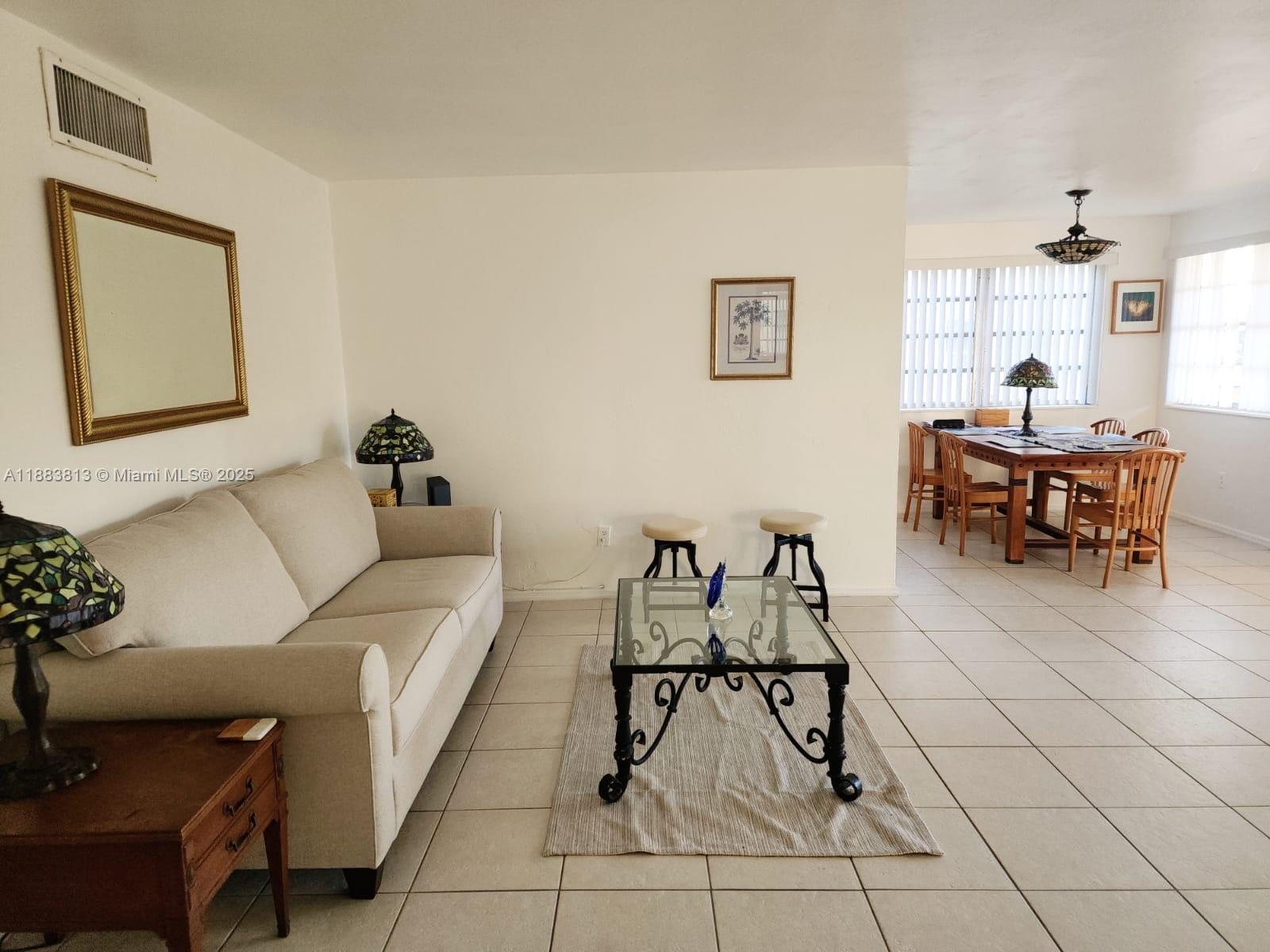 11960 Northeast 19th Drive, Unit 10 North Miami, FL 33181 - Photo 14 of 40 a living room with furniture and a dining table