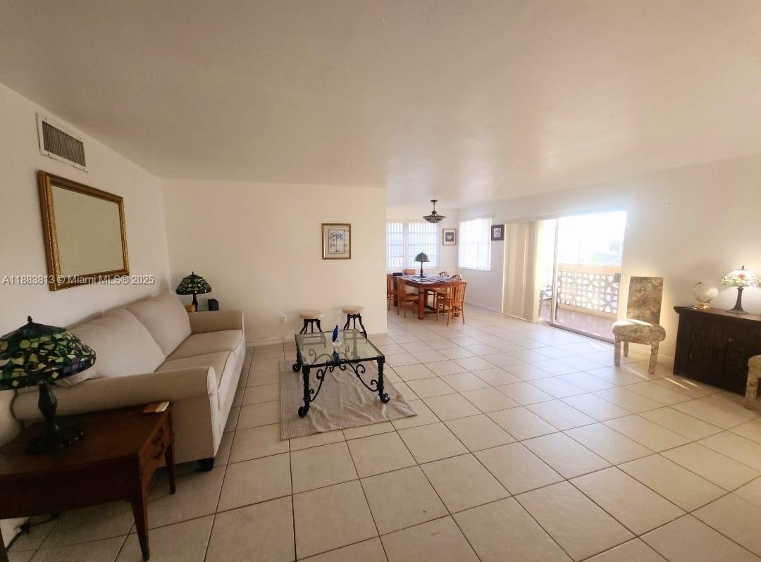 11960 Northeast 19th Drive, Unit 10 North Miami, FL 33181 - Photo 19 of 40 a living room with furniture and a table