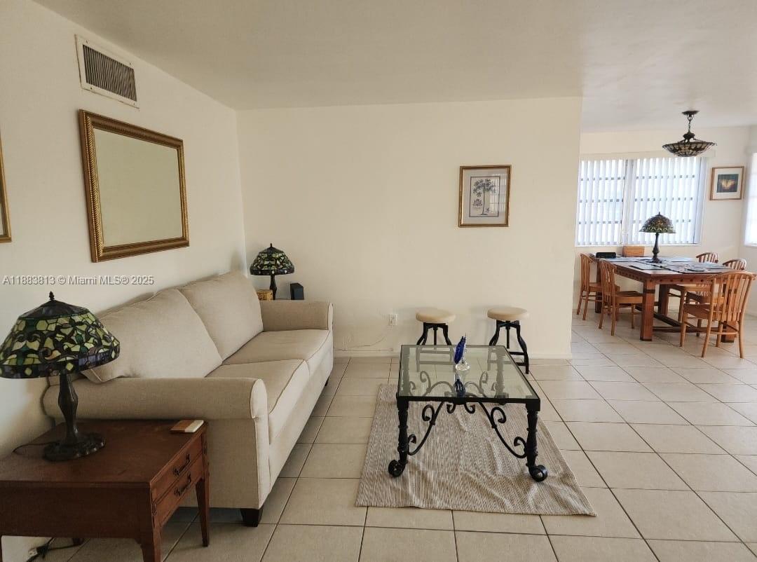 11960 Northeast 19th Drive, Unit 10 North Miami, FL 33181 - Photo 23 of 40 a living room with furniture and white walls