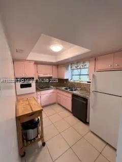 a kitchen with granite countertop a refrigerator and a stove top oven