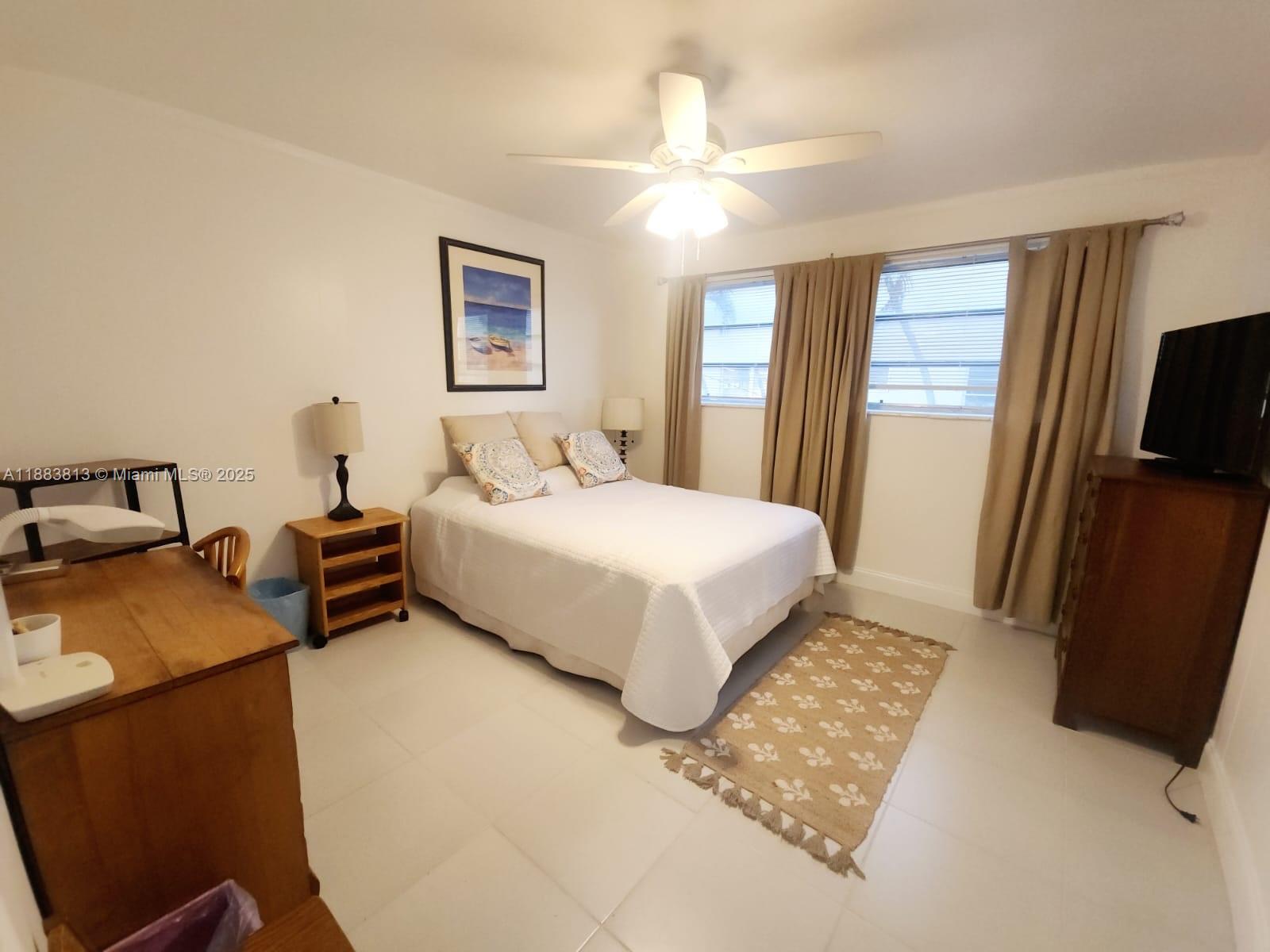 11960 Northeast 19th Drive, Unit 10 North Miami, FL 33181 - Photo 3 of 40 a bedroom with a bed and wooden floor